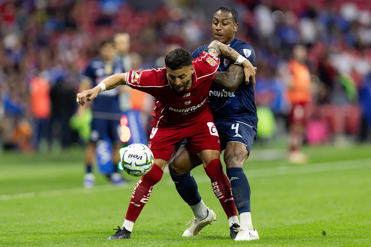 Alexis Vega (izq.) de Toluca disputa el balón con Willer Ditta (der.) de Cruz Azul durante el partido de la Jornada 10 entre Cruz Azul y Toluca.