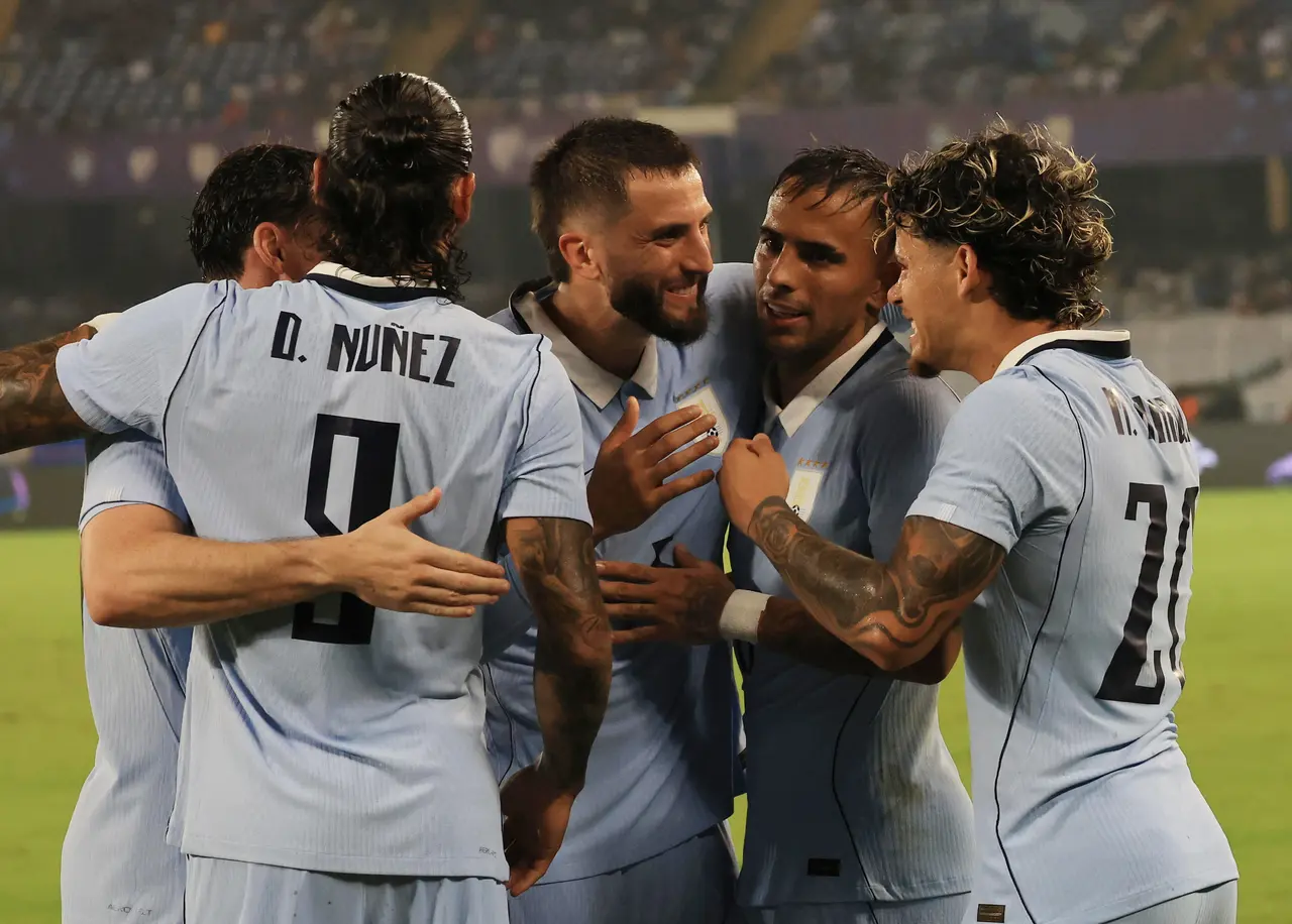 Uruguay's Maximiliano Araujo (R) celebrates with teammates after scoring a goal during the international soccer friendly match