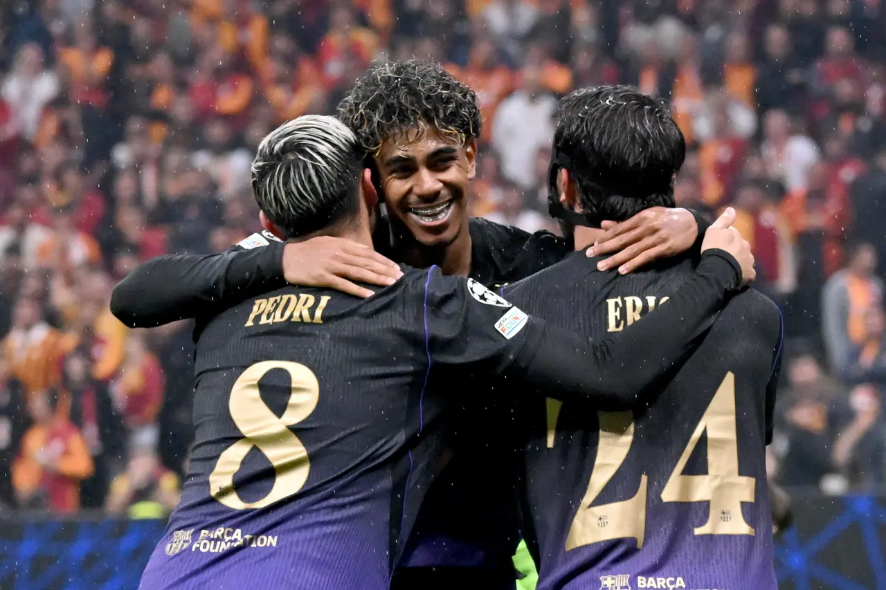 Lamine Yamal (C) Barcelona celebrates with teammates Pedri (L) and Eric Garcia (R) during the UEFA Champions League 