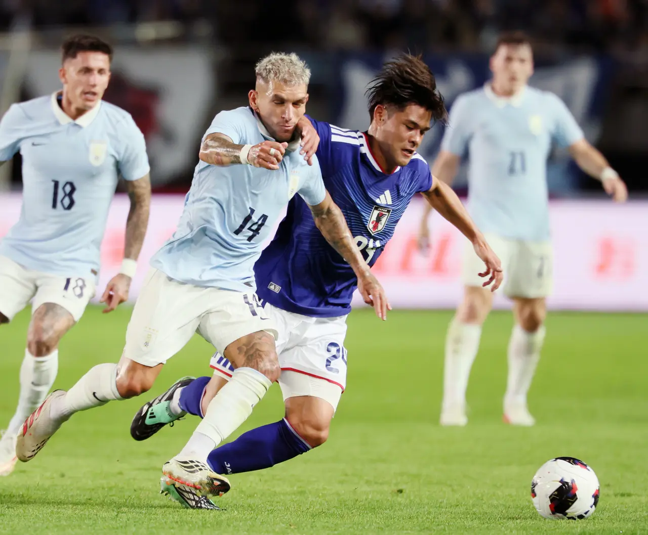 El japonés Kaishu Sano (derecha) disputa el balón ante Lucas Sebastián Torreira Di Pascua durante el partido amistoso entre Japón y Uruguay, celebrado en el Estadio Miyagi, en Rifu, Miyagi.