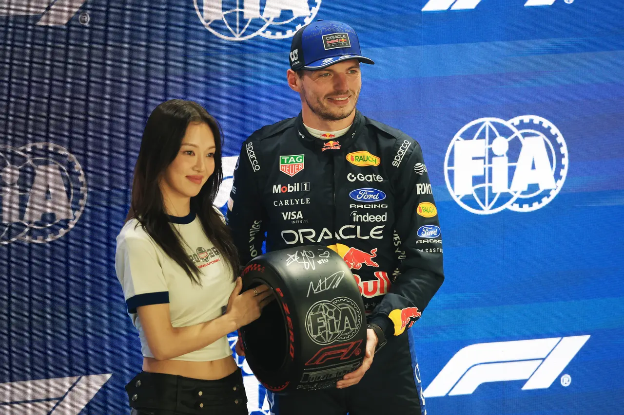 Red Bull Racing driver Max Verstappen of Netherlands (R) receives his Pirelli Pole Position award from South Korean singer 