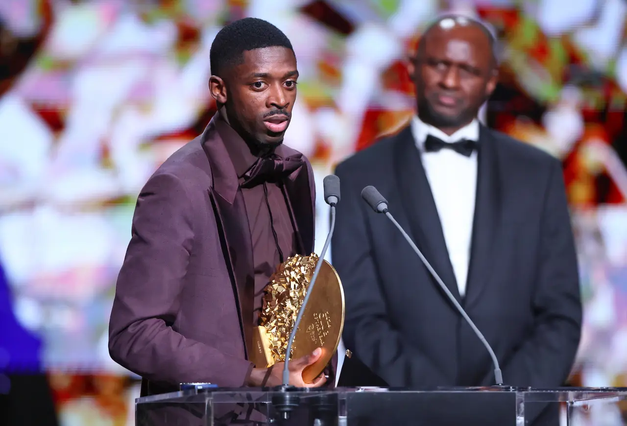 Paris Saint-Germain forward Ousmane Dembele collects the award on behalf of the team after PSG won the Men's Club of the Year