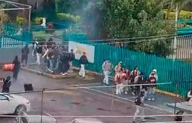 Estudiantes salen del Colegio de Bachilleres 6 en Iztapalapa tras el lanzamiento de cohetones al interior del plantel.