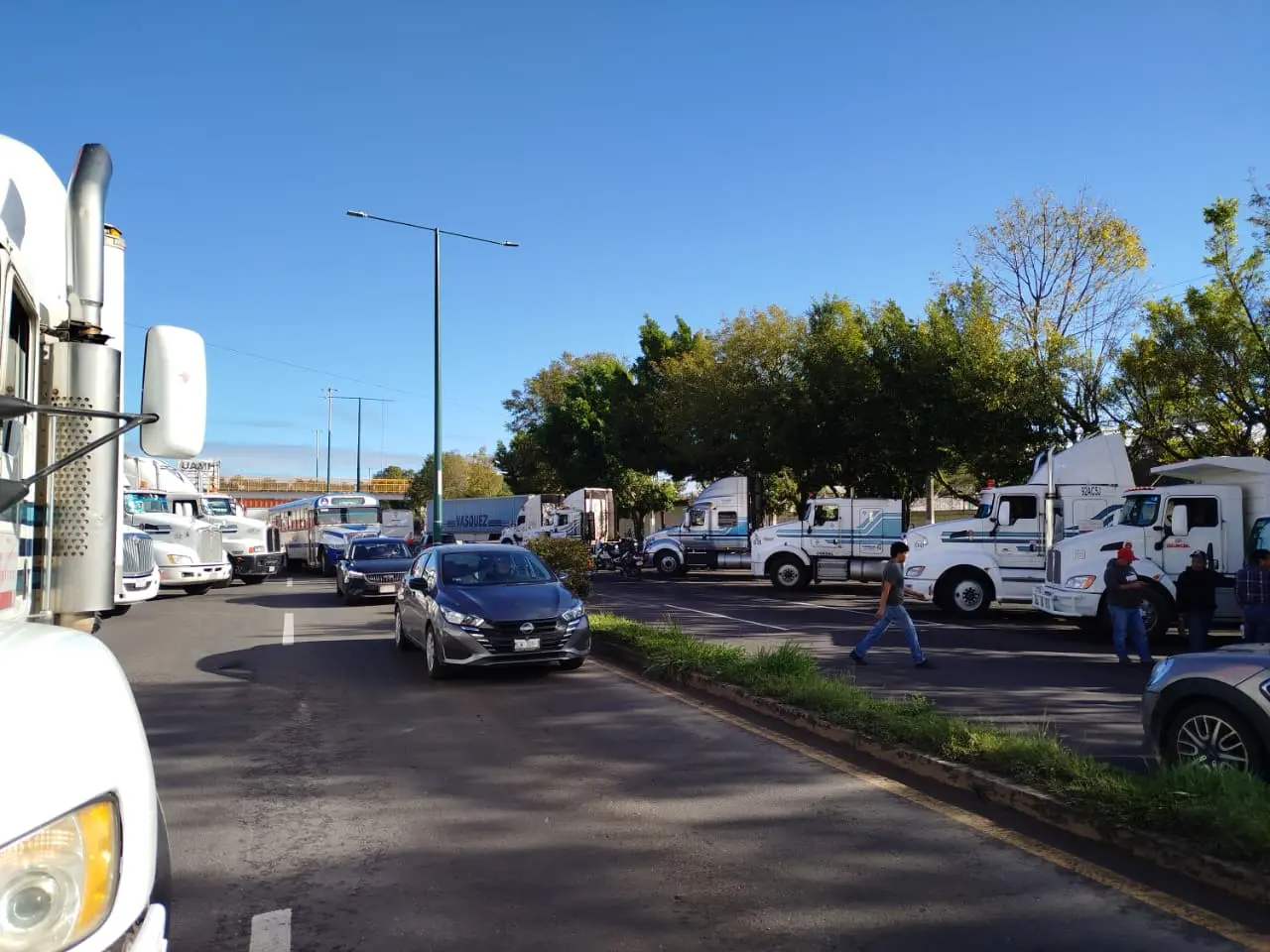 Autobuses y camiones de carga participan en el paro de transportistas sobre una carretera de México.